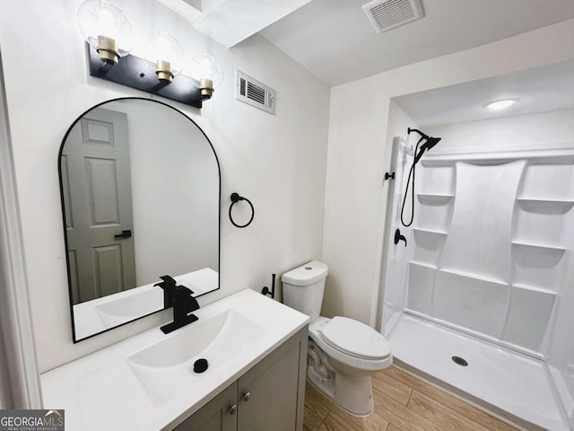 bathroom with toilet, walk in shower, and vanity