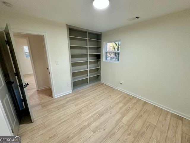 unfurnished bedroom with light wood-type flooring and a closet