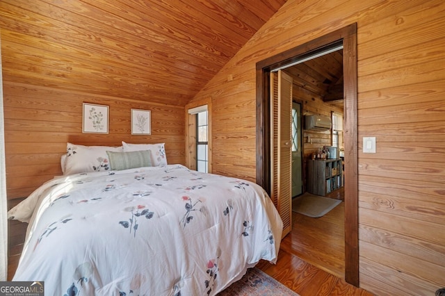 bedroom featuring wood ceiling, vaulted ceiling, wooden walls, wood-type flooring, and a closet