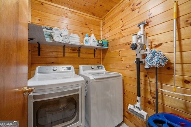 laundry room featuring washer and dryer, wooden ceiling, and wooden walls