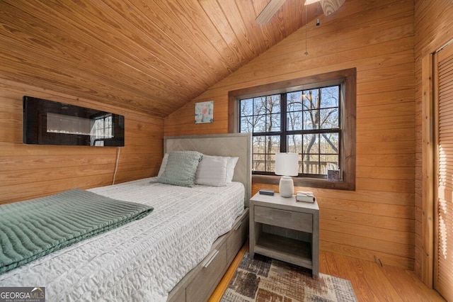 bedroom featuring wooden walls, wooden ceiling, vaulted ceiling, and light hardwood / wood-style floors