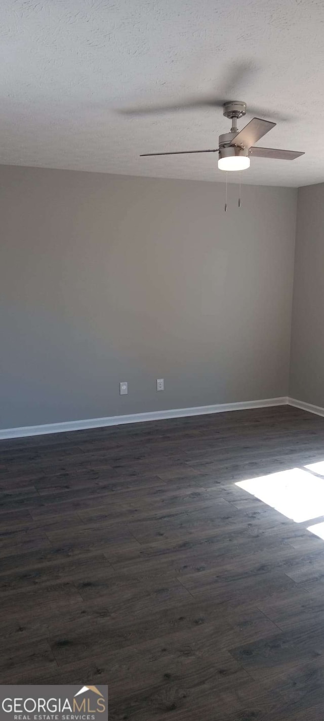 unfurnished room featuring a textured ceiling and dark hardwood / wood-style floors