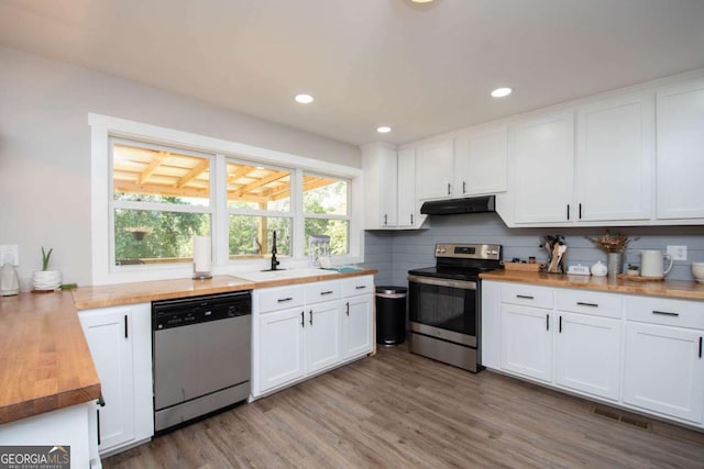 kitchen featuring white cabinetry, sink, stainless steel appliances, butcher block countertops, and light wood-type flooring