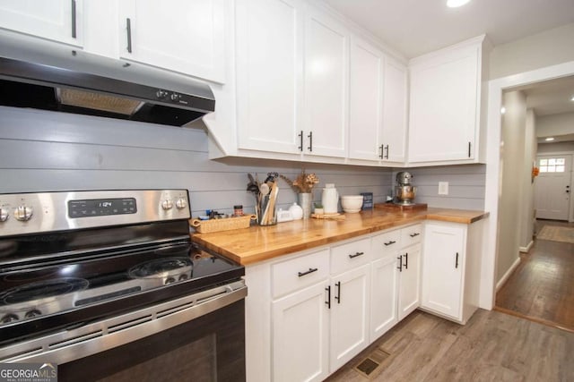 kitchen with wood counters, decorative backsplash, light hardwood / wood-style flooring, white cabinetry, and stainless steel electric range