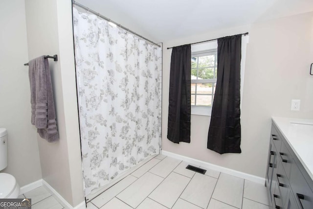 bathroom featuring tile patterned floors, vanity, toilet, and walk in shower