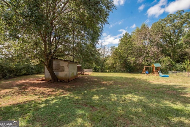 view of yard featuring a playground and a storage shed