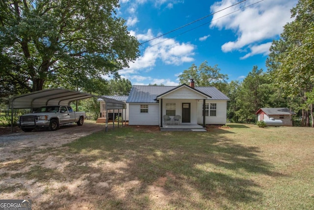 view of front of home with a front lawn, covered porch, and a carport