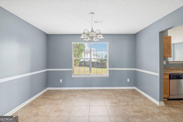 unfurnished dining area featuring light tile patterned floors, a textured ceiling, and a chandelier