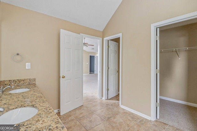 bathroom featuring tile patterned flooring, vanity, and vaulted ceiling