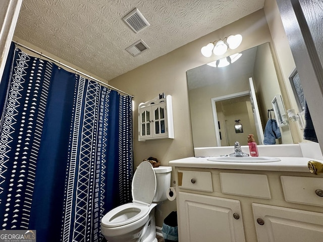 bathroom featuring vanity, a textured ceiling, and toilet