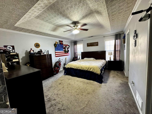 carpeted bedroom featuring crown molding, ceiling fan, and a tray ceiling