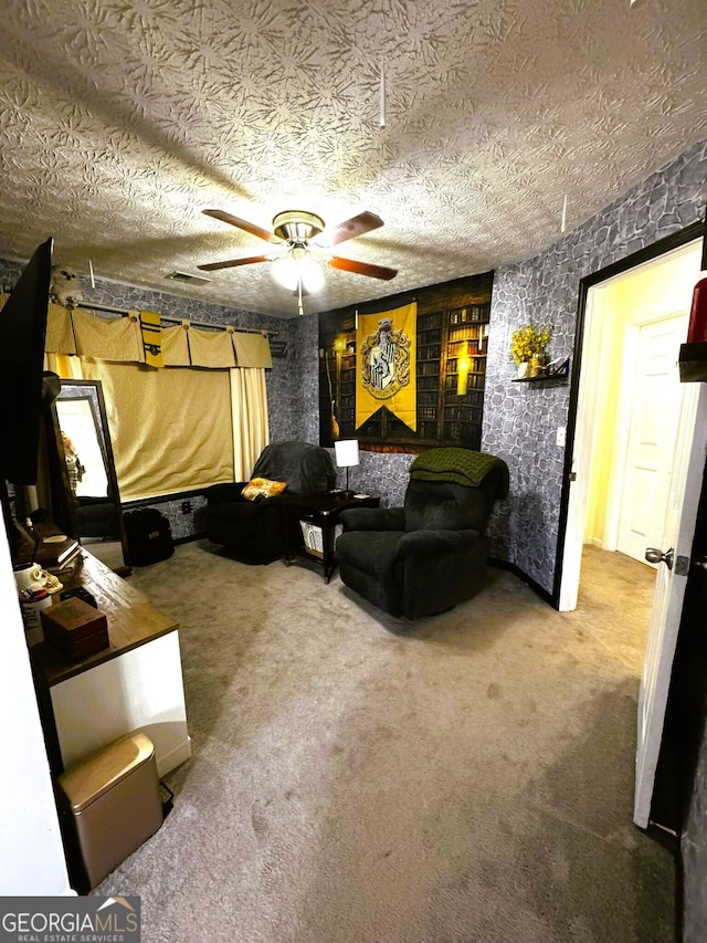 carpeted cinema room featuring a textured ceiling and ceiling fan