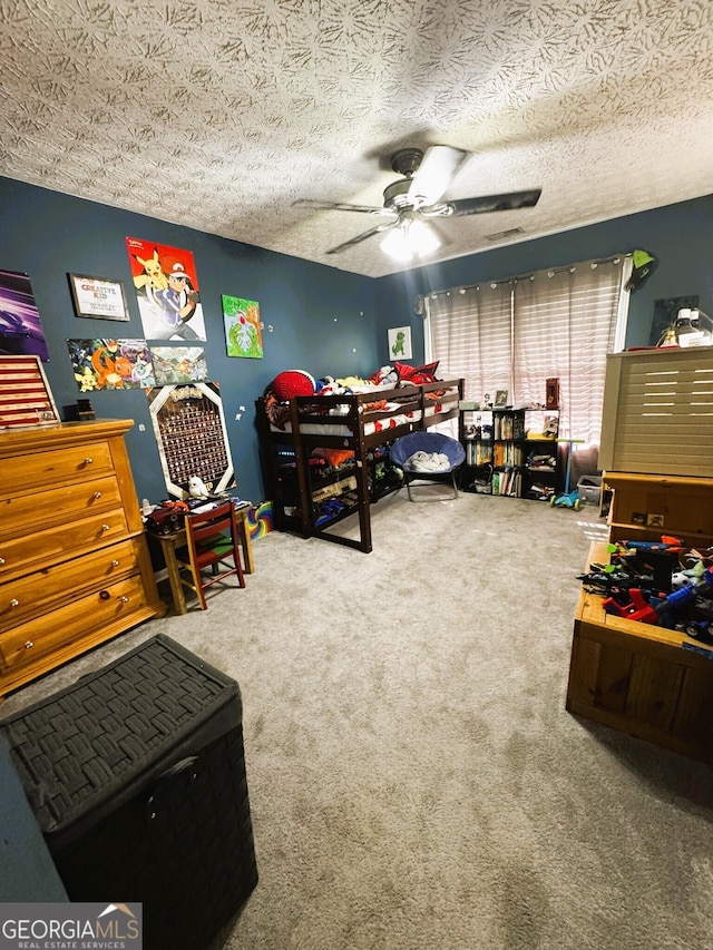 carpeted bedroom with ceiling fan and a textured ceiling