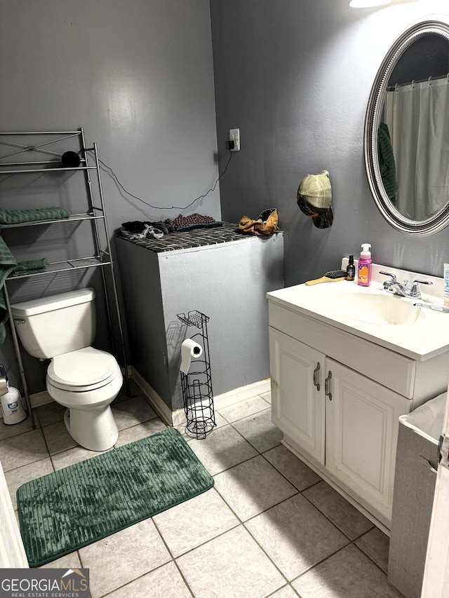 bathroom with tile patterned flooring, vanity, and toilet