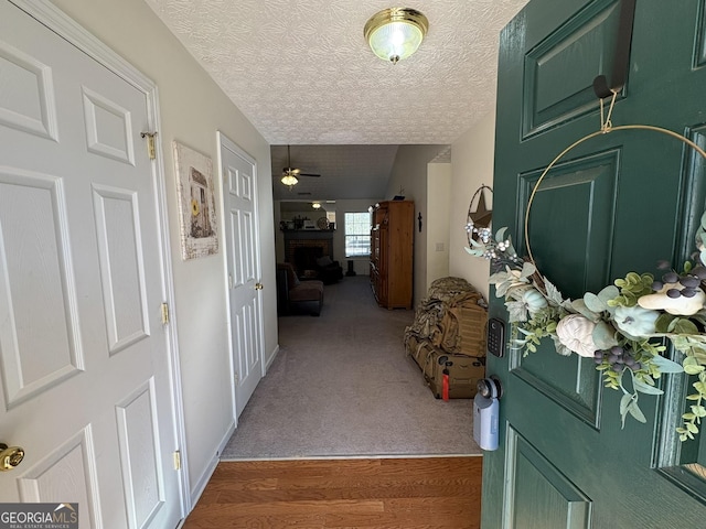 interior space with ceiling fan, dark carpet, and a textured ceiling