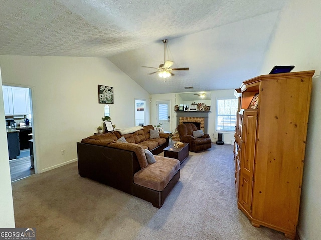 carpeted living room featuring ceiling fan, a fireplace, vaulted ceiling, and a textured ceiling