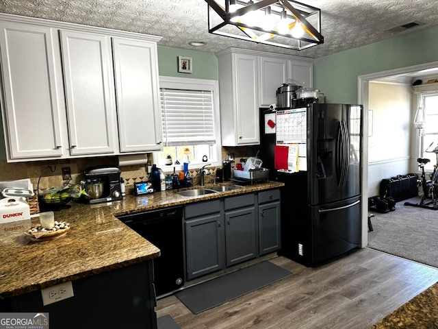 504 Plantation Creek Dr, Loganville, GA 30052 - kitchen with a sink, black appliances, wood finished floors, and white cabinetry