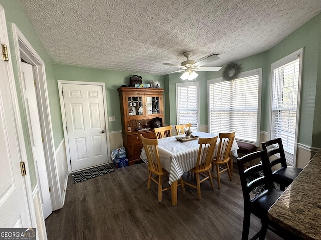 dining space featuring a textured ceiling, dark hardwood / wood-style floors, and ceiling fan