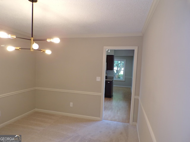 carpeted empty room with a textured ceiling and crown molding