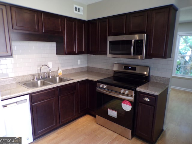 kitchen featuring light hardwood / wood-style floors, dark brown cabinetry, sink, and appliances with stainless steel finishes