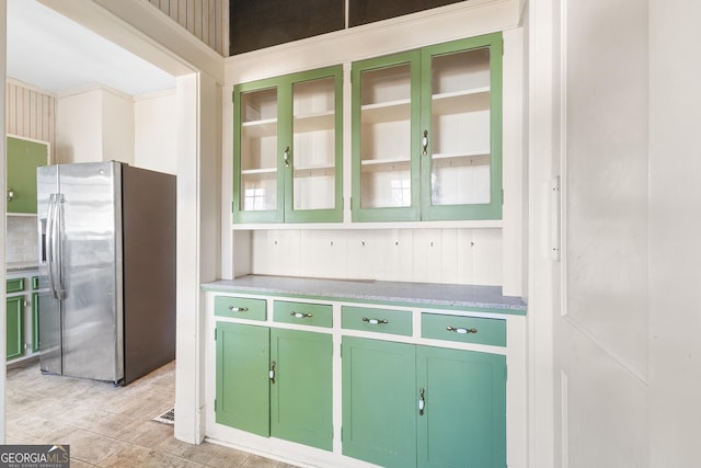 kitchen with stainless steel fridge with ice dispenser and green cabinetry