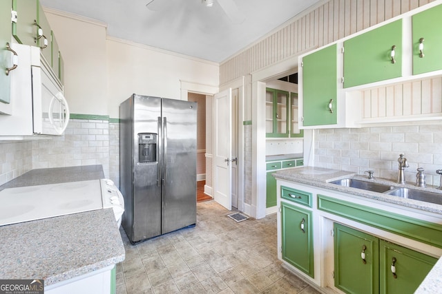 kitchen featuring stainless steel fridge with ice dispenser, green cabinets, stove, light stone countertops, and sink