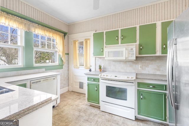 kitchen featuring light stone counters, white appliances, and green cabinets