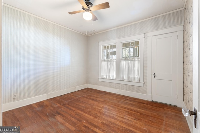 unfurnished room featuring ceiling fan, dark hardwood / wood-style flooring, and ornamental molding