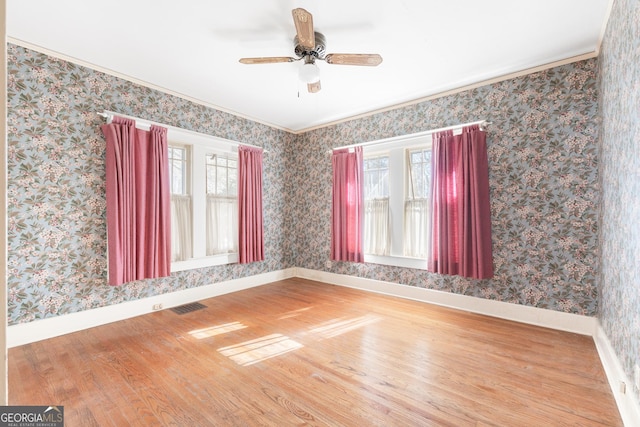 unfurnished room with ceiling fan, ornamental molding, and wood-type flooring