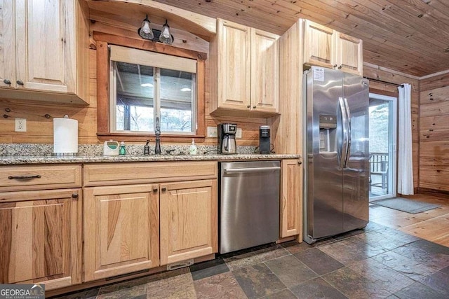 kitchen with sink, light stone counters, wooden walls, wood ceiling, and appliances with stainless steel finishes