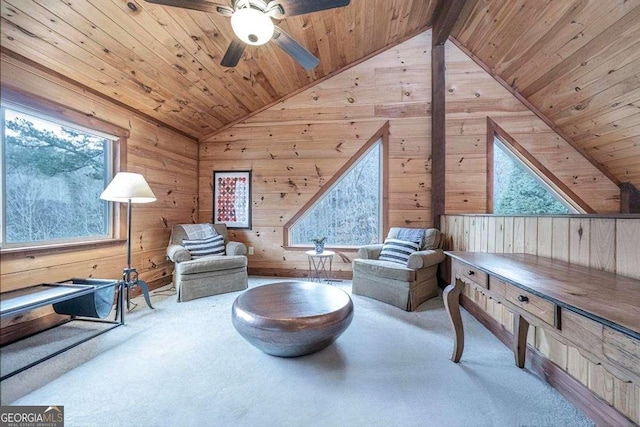 sitting room with lofted ceiling with beams, wood walls, carpet floors, and wood ceiling