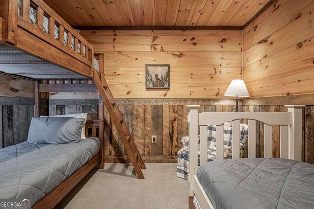 carpeted bedroom featuring wood walls and wooden ceiling