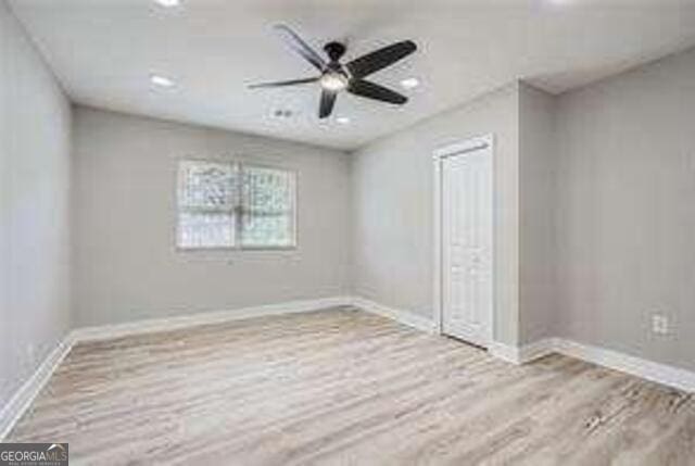 unfurnished bedroom featuring ceiling fan, light hardwood / wood-style floors, and a closet