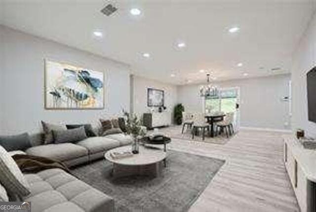 living room with a chandelier and light hardwood / wood-style flooring