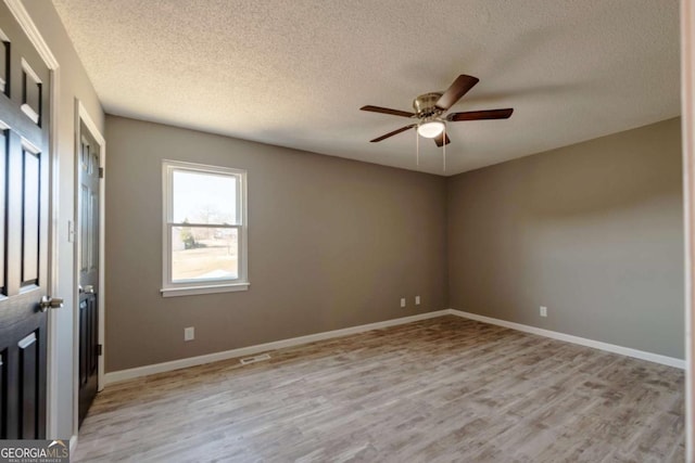 unfurnished room featuring ceiling fan, light hardwood / wood-style flooring, and a textured ceiling