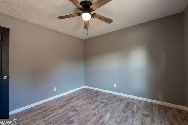 spare room with a textured ceiling, hardwood / wood-style flooring, and ceiling fan