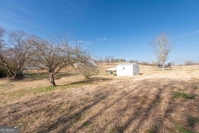 view of yard featuring a storage unit and a rural view