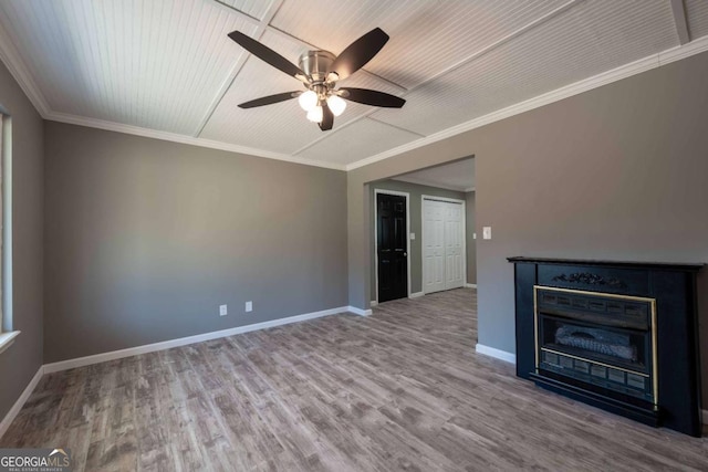 unfurnished living room with ceiling fan, crown molding, wood-type flooring, and a fireplace