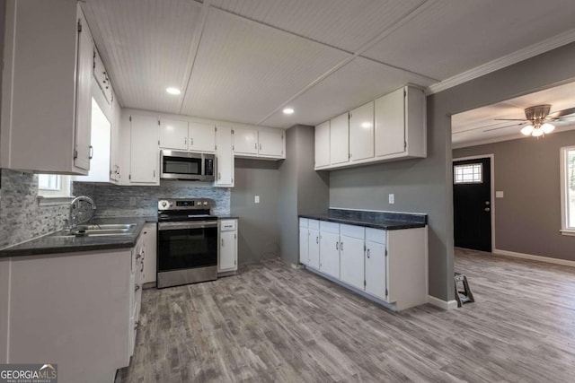 kitchen featuring white cabinets, stainless steel appliances, plenty of natural light, and sink