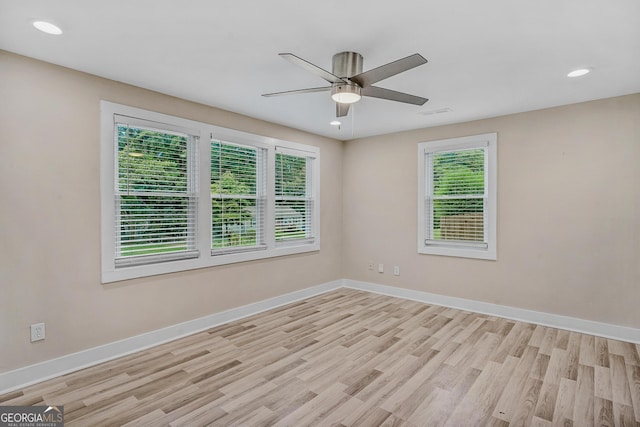 spare room featuring plenty of natural light, ceiling fan, and light hardwood / wood-style flooring