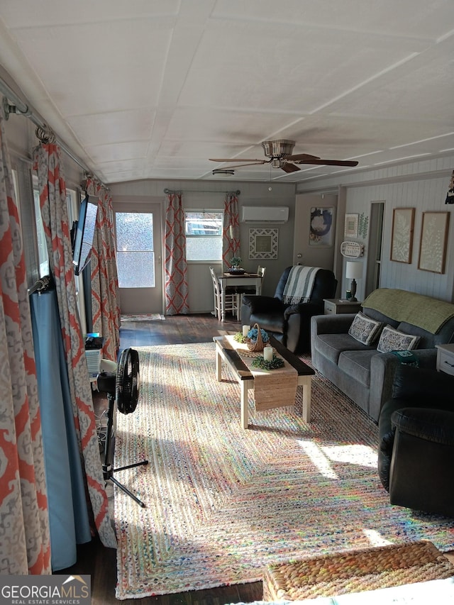 living room featuring a wall unit AC and ceiling fan