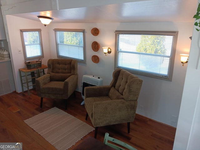 sitting room featuring heating unit and hardwood / wood-style flooring