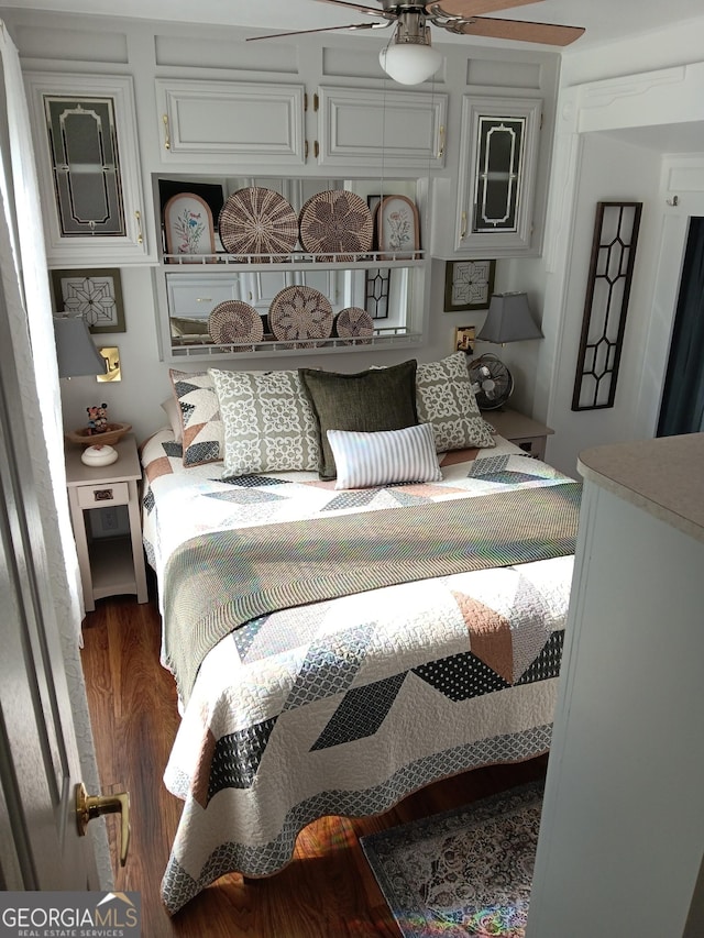 bedroom with dark hardwood / wood-style floors and ceiling fan