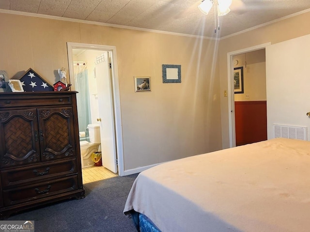 bedroom with carpet floors, ensuite bath, and crown molding