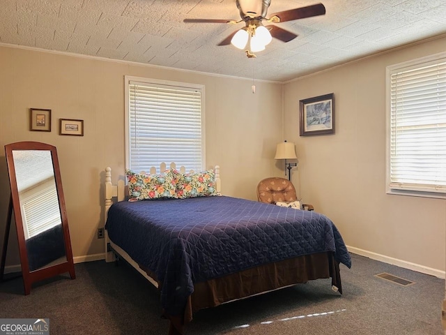 bedroom featuring ceiling fan, dark carpet, and crown molding