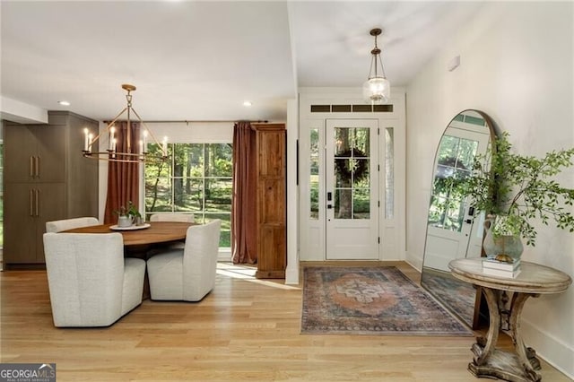 foyer entrance with a notable chandelier and light wood-type flooring