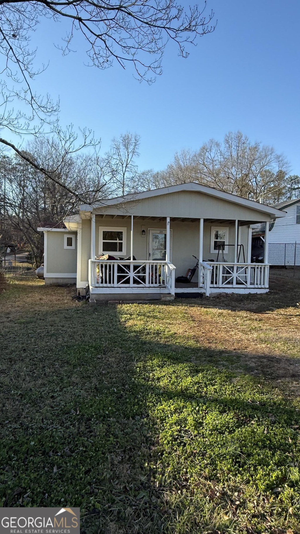 back of house with a porch and a yard