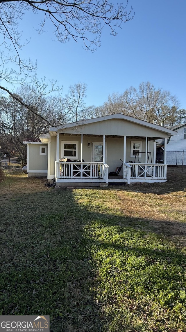 back of house with a porch and a yard