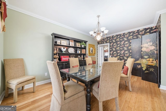 dining room with crown molding, baseboards, wallpapered walls, a notable chandelier, and light wood finished floors