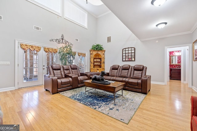 living room with french doors, crown molding, visible vents, light wood finished floors, and baseboards